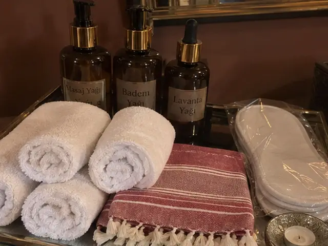 Masaj yağları, rulo havlular, kırmızı çizgili peştemal ve terlik — Kumkapı, Masaj Salonun